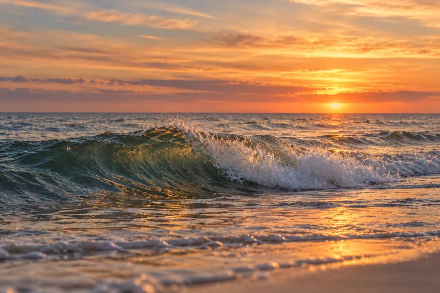 Welle auf ruhigem Meer bei Sonnenuntergang